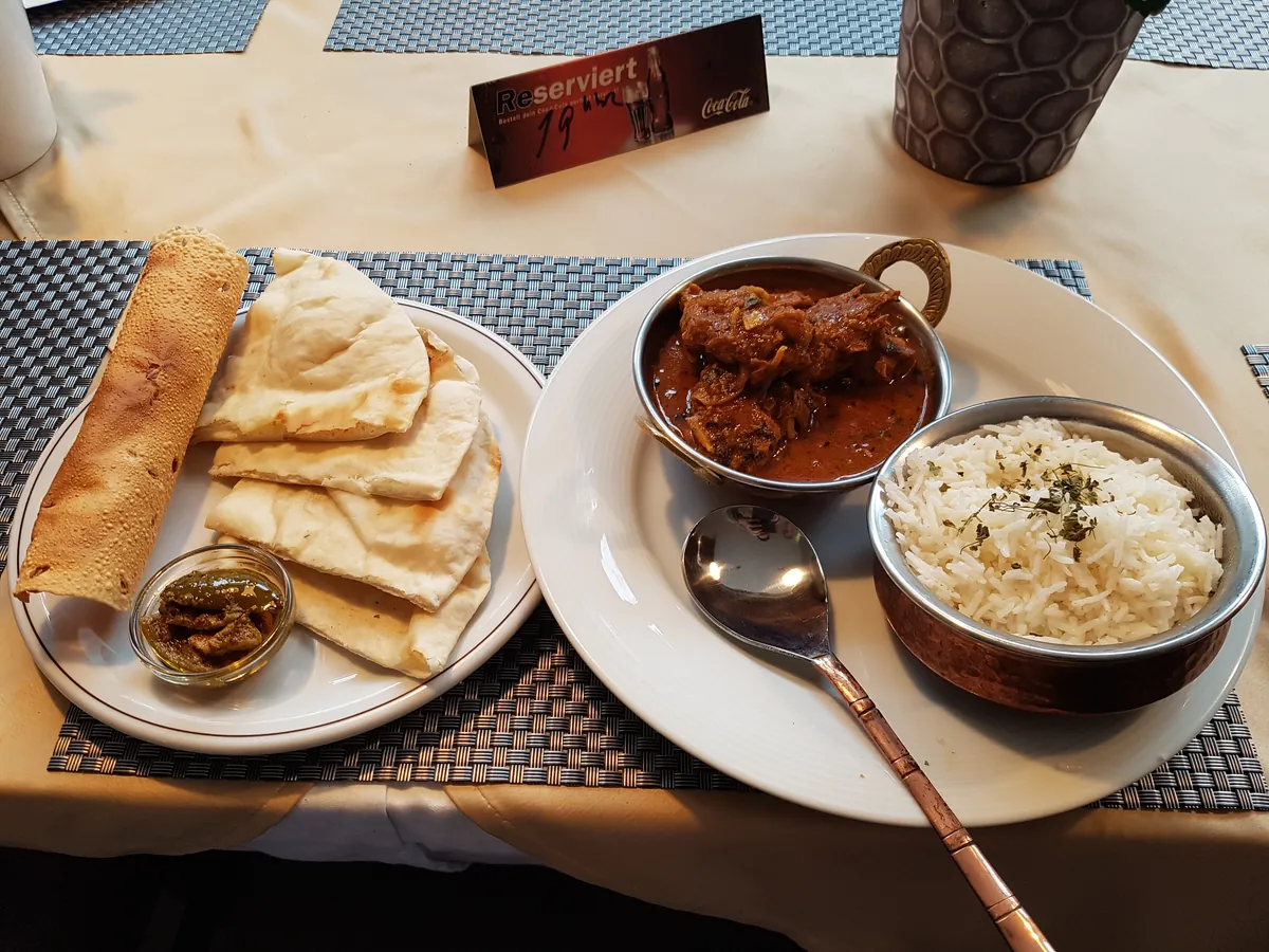 Curry mit Naan und Reis am Tisch im Café Hufeisen